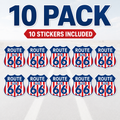 A 10-pack of Route 66 stickers, featuring ten classic shield-shaped stickers with red and white vertical stripes, a blue border, and 'ROUTE 66' in white and blue text. The image includes promotional text at the top reading '10 PACK' and '10 STICKERS INCLUDED' against a light gray road background.